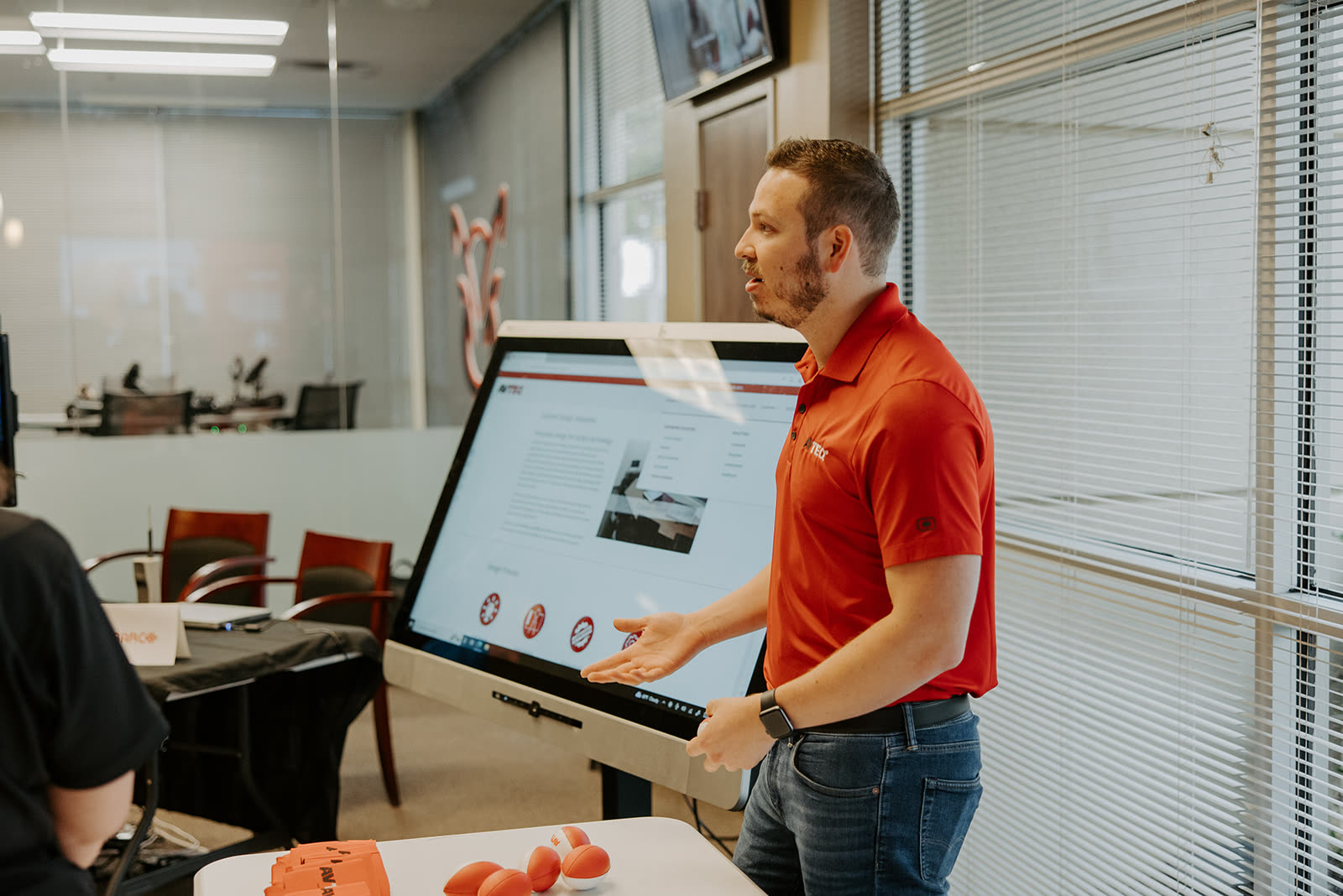 A specialist demonstrating an interactive kiosk