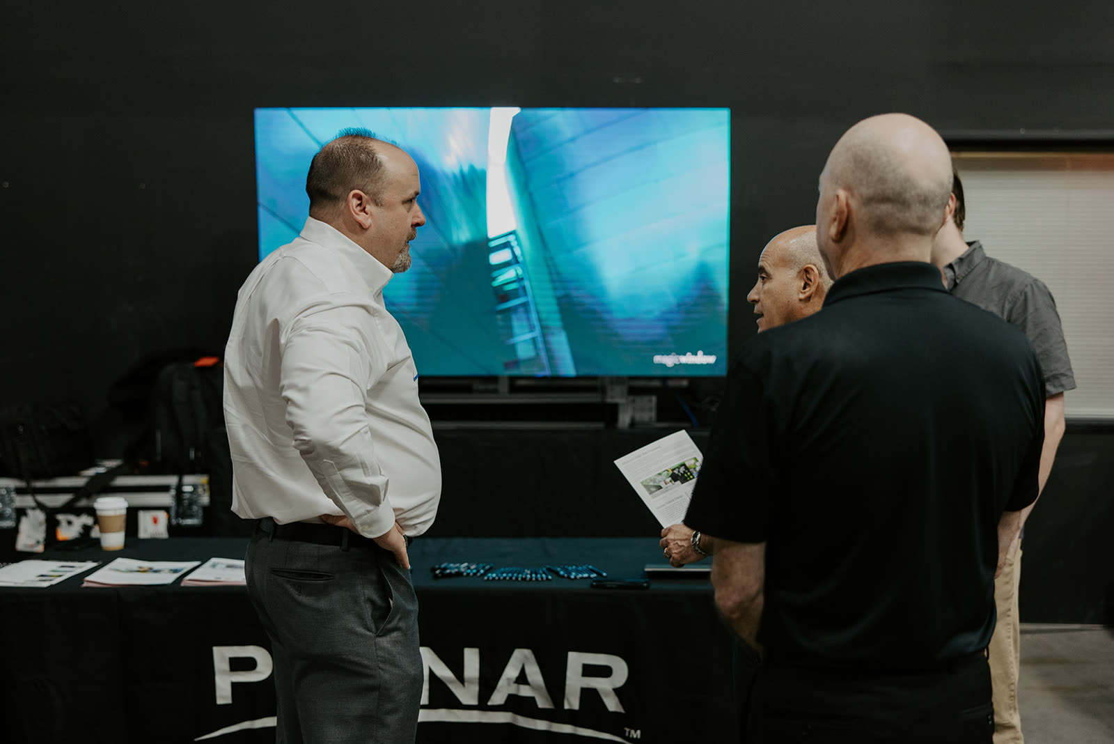 Attendees watching a large display demo at the Planar booth